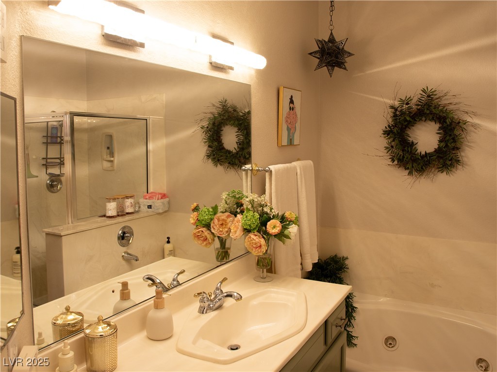 2050 West Warm Springs Road, Unit 411 Henderson, NV 89014 - Photo 16 of 30 Full bathroom featuring vanity, a shower stall, and a jetted tub