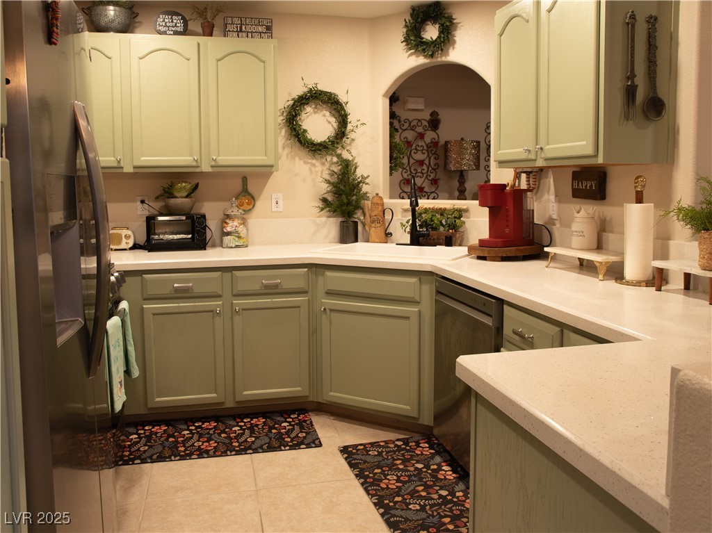 2050 West Warm Springs Road, Unit 411 Henderson, NV 89014 - Photo 2 of 30 Kitchen with light tile patterned floors, light countertops, stainless steel appliances, and arched walkways