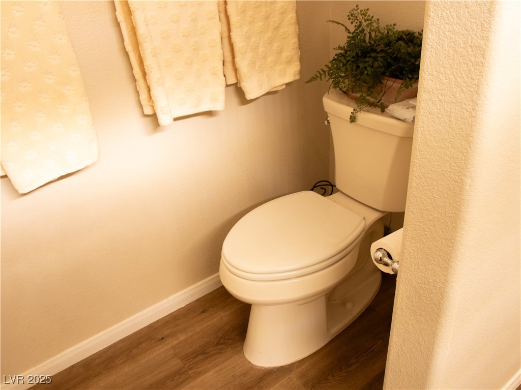 2050 West Warm Springs Road, Unit 411 Henderson, NV 89014 - Photo 30 of 30 Bathroom featuring toilet, baseboards, and wood finished floors