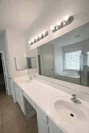 a bathroom with a double vanity sink and a mirror