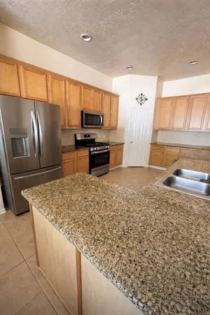 a kitchen with stainless steel appliances granite countertop a sink refrigerator and microwave