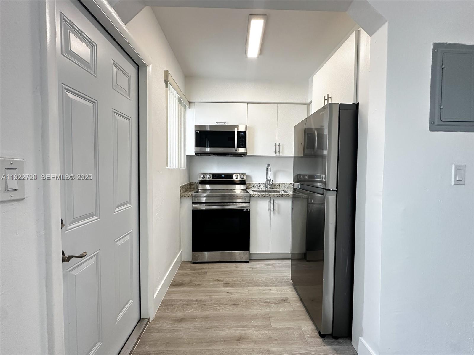 1894 Northwest 53rd Street, Unit A Miami, FL 33142 - Photo 5 of 10 a kitchen with a refrigerator stove and microwave