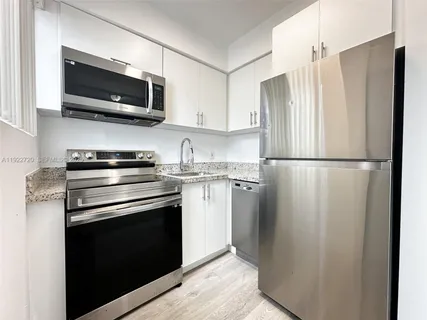 a kitchen with stainless steel appliances a refrigerator stove and microwave