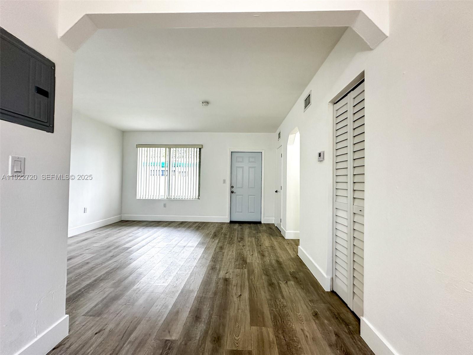 1894 Northwest 53rd Street, Unit A Miami, FL 33142 - Photo 7 of 10 a view of an empty room with wooden floor and a window