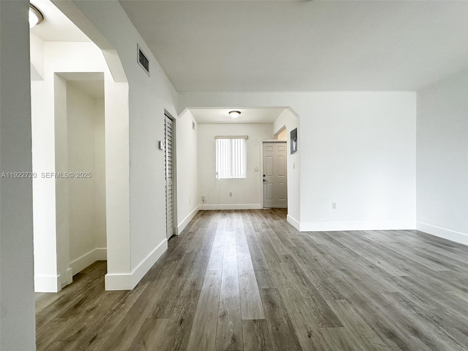1894 Northwest 53rd Street, Unit A Miami, FL 33142 - Photo 8 of 10 a view of a room with wooden floor and white doors