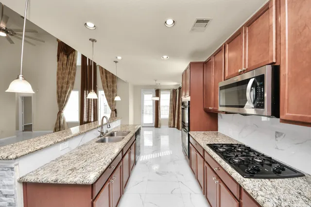 a large kitchen with granite countertop a stove and a sink