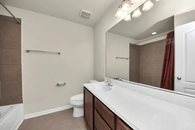 a bathroom with a sink a toilet and a large mirror