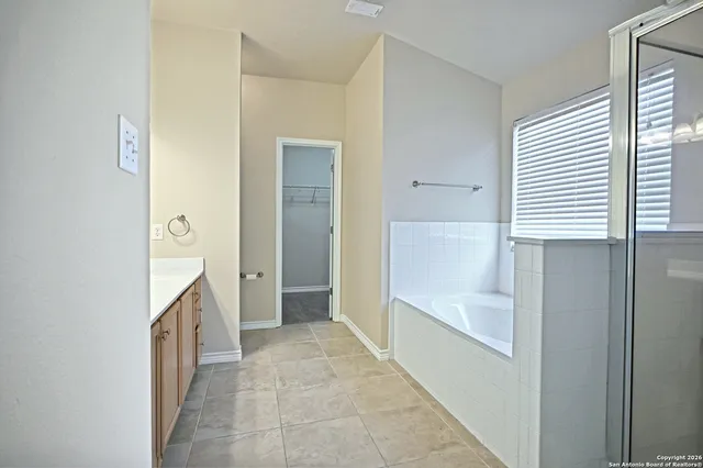 a bathroom with a bathtub sink and mirror