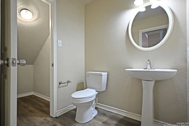 a bathroom with a toilet sink and mirror