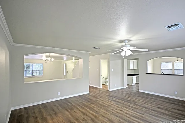 an empty room with wooden floor chandelier and glass door