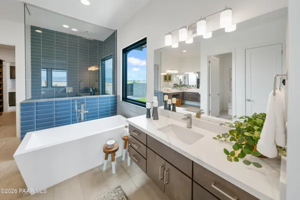 a bathroom with a tub a sink and mirror