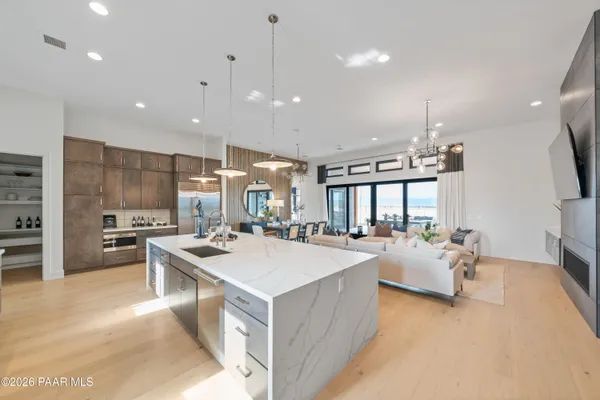 a large kitchen with kitchen island a large counter top space a sink stainless steel appliances and cabinets