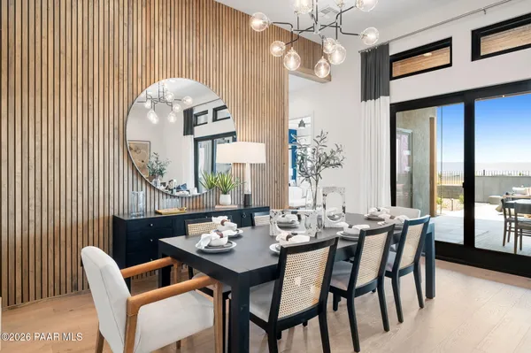 a dining room with chandelier fan and wooden floor