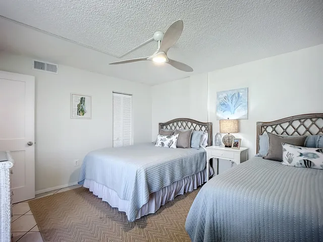 a view of a hallway with wooden floor and a bathroom