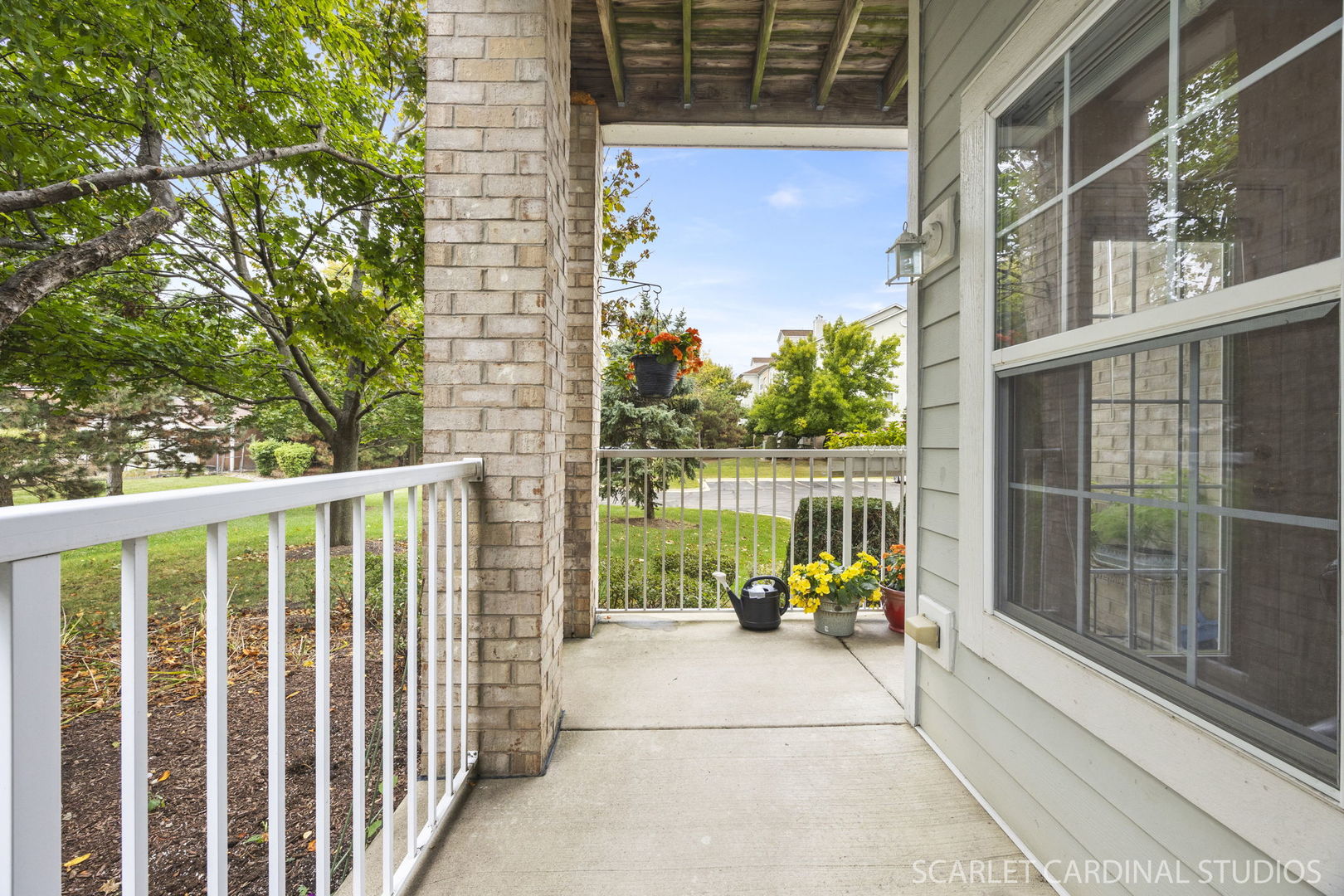 1275 West Lake Street, Unit 104 Addison, IL 60101 - Photo 19 of 20 a view of a balcony with potted plants and floor to ceiling window and wooden fence