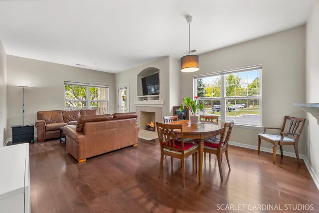 a living room with furniture a dining table and a floor to ceiling window