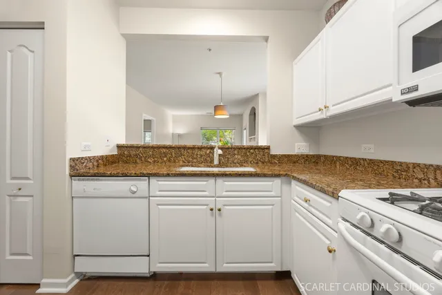 a kitchen with granite countertop white cabinets and a stove