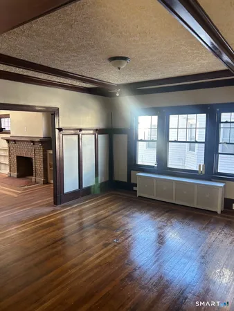 an empty room with wooden floor and fireplace