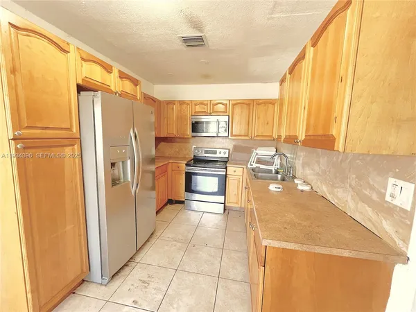 a kitchen with stainless steel appliances a refrigerator and a stove