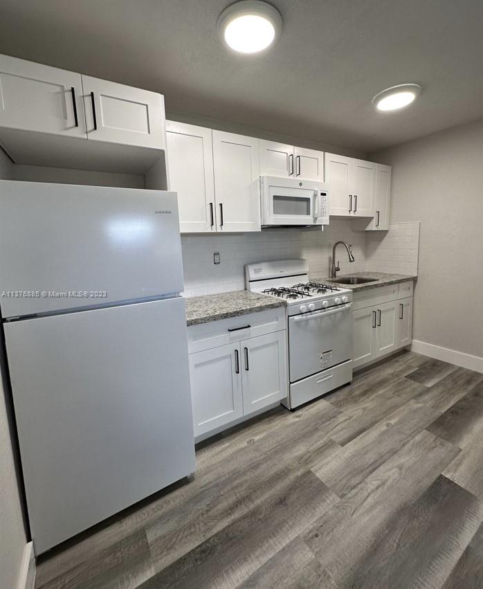 a kitchen with stainless steel appliances a refrigerator sink and white cabinets