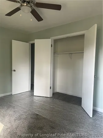 an empty room with closet and windows
