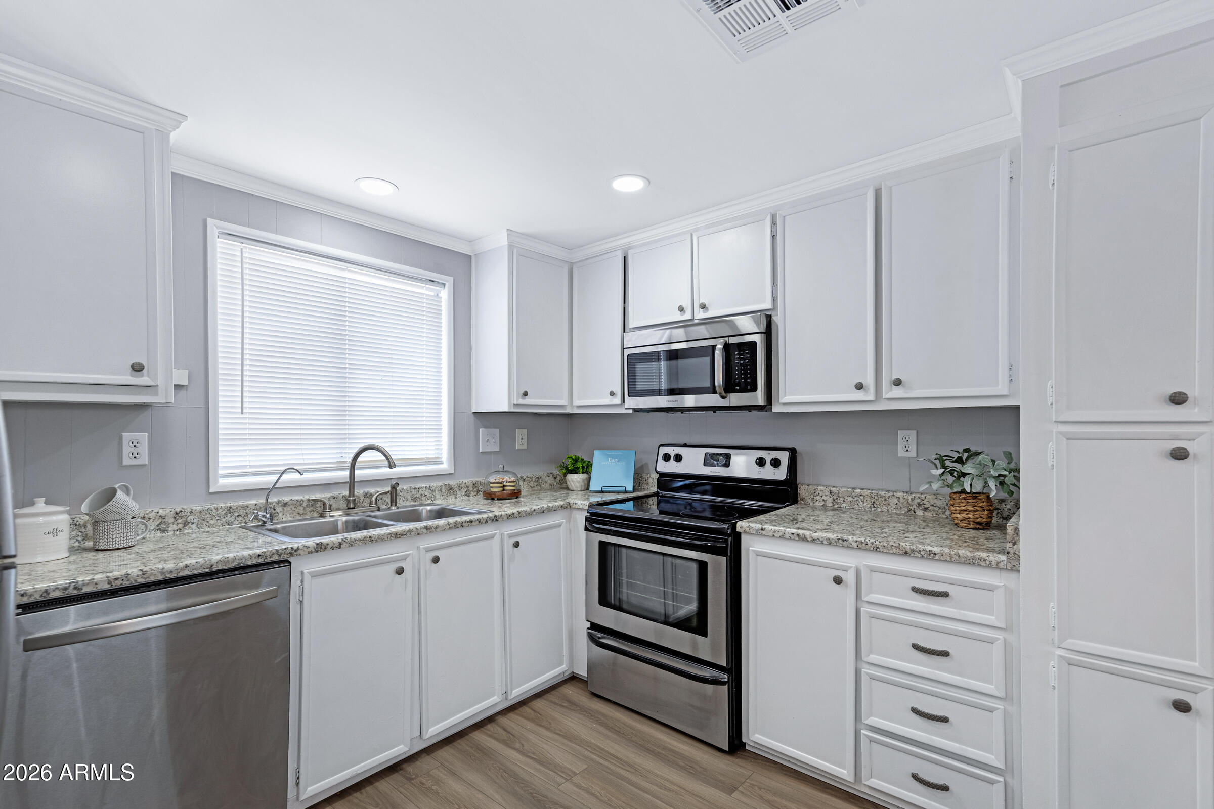 201 South Greenfield Road, Unit 269 Mesa, AZ 85206 - Photo 5 of 18 a kitchen with stainless steel appliances granite countertop a sink dishwasher a stove and a microwave oven with cabinets