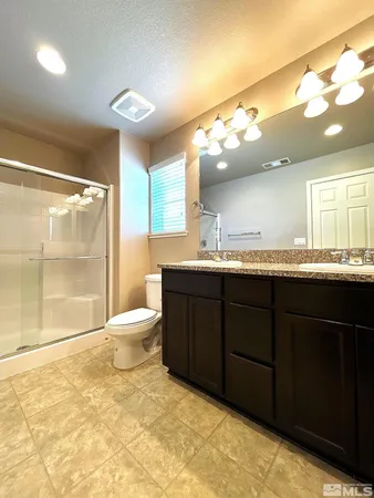 a bathroom with a sink a toilet and a large mirror