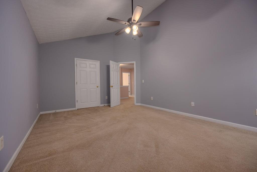 6280 Lake Valley Point Lithonia, GA 30058 - Photo 14 of 30 an empty room with a chandelier fan and windows