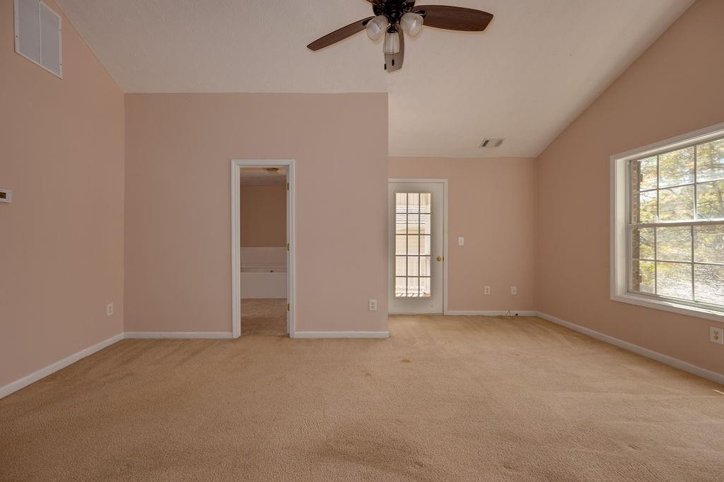 6280 Lake Valley Point Lithonia, GA 30058 - Photo 17 of 30 an empty room with chandelier fan and windows