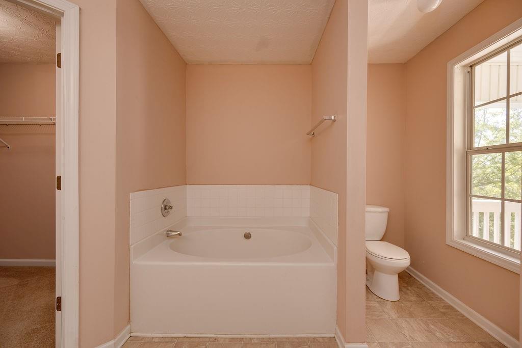 6280 Lake Valley Point Lithonia, GA 30058 - Photo 19 of 30 a white bath tub sitting next to a white toilet