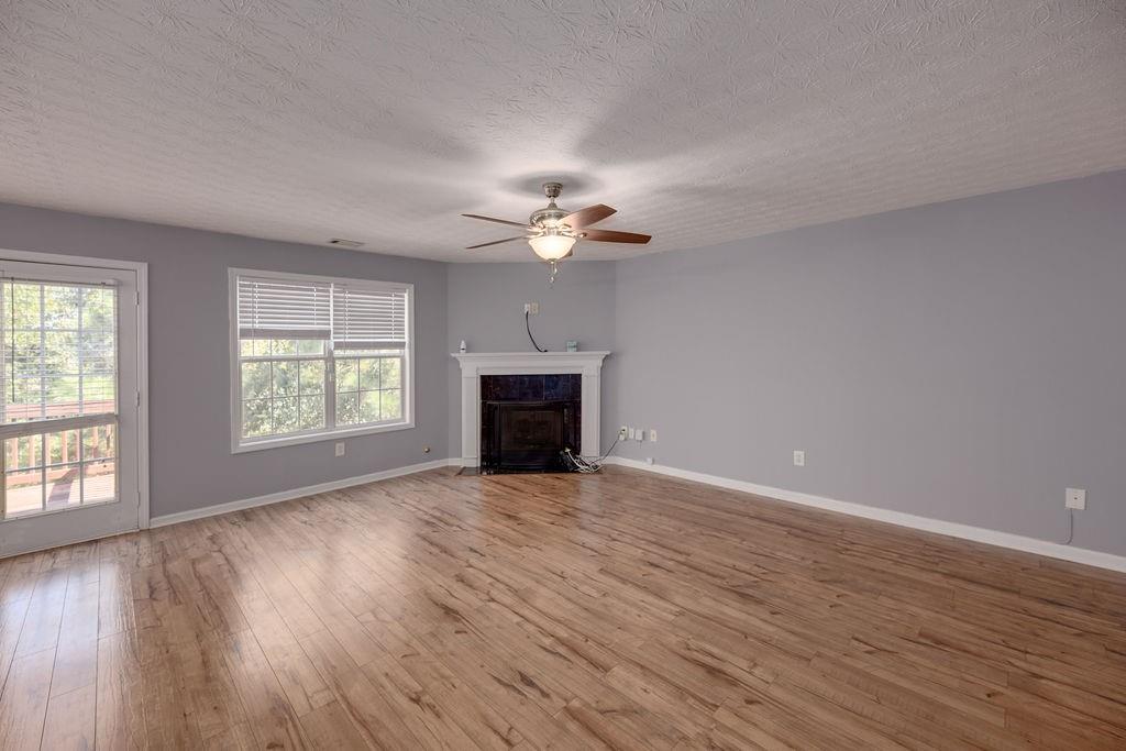 6280 Lake Valley Point Lithonia, GA 30058 - Photo 7 of 30 an empty room with wooden floor fan and windows