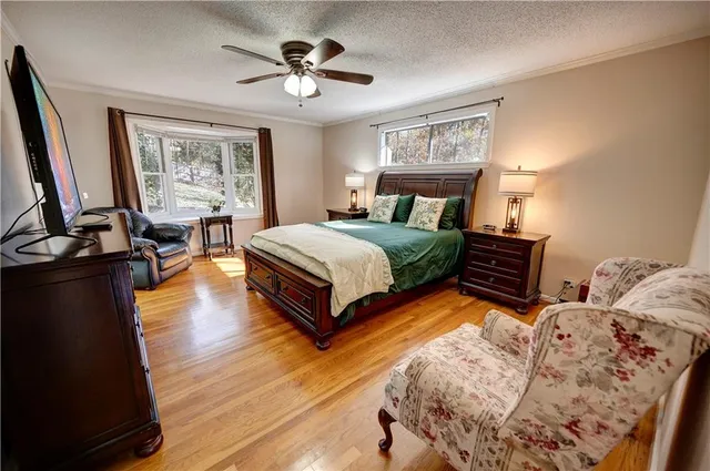 a kitchen with stainless steel appliances granite countertop a stove top oven a sink dishwasher and white cabinets with wooden floor