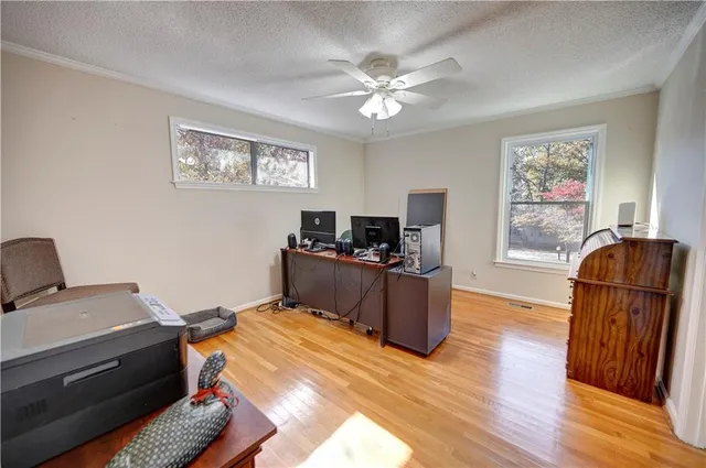 a kitchen with stainless steel appliances kitchen island granite countertop a refrigerator a stove top oven a sink dishwasher and white cabinets with wooden floor