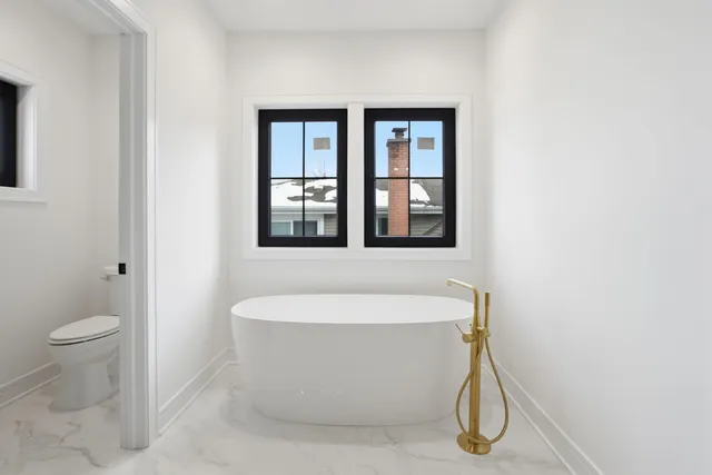 a white bath tub sitting next to a toilet