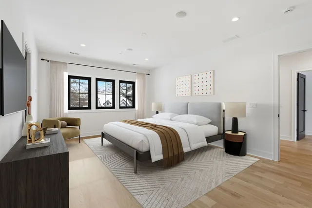 a spacious bedroom with a bed and wooden floor