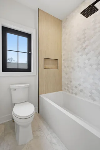 a white toilet sitting next to a bath tub