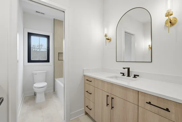 a bathroom with a toilet sink and mirror