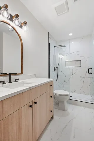 a bathroom with a toilet sink and mirror