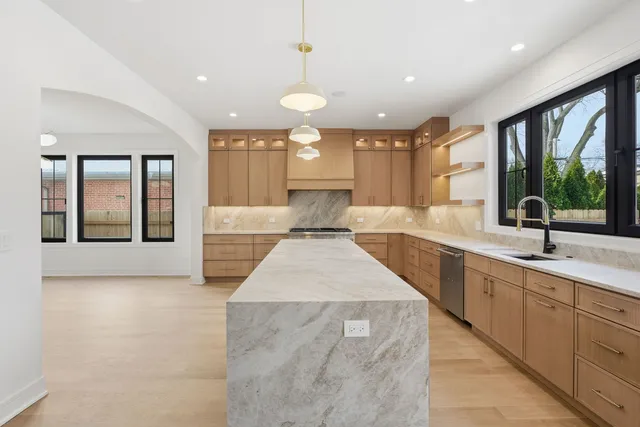 a large kitchen with kitchen island a large window sink and cabinets