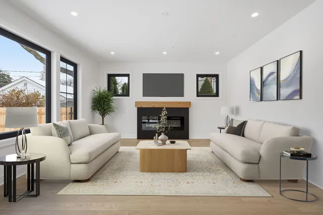 a living room with furniture a fireplace and a large window