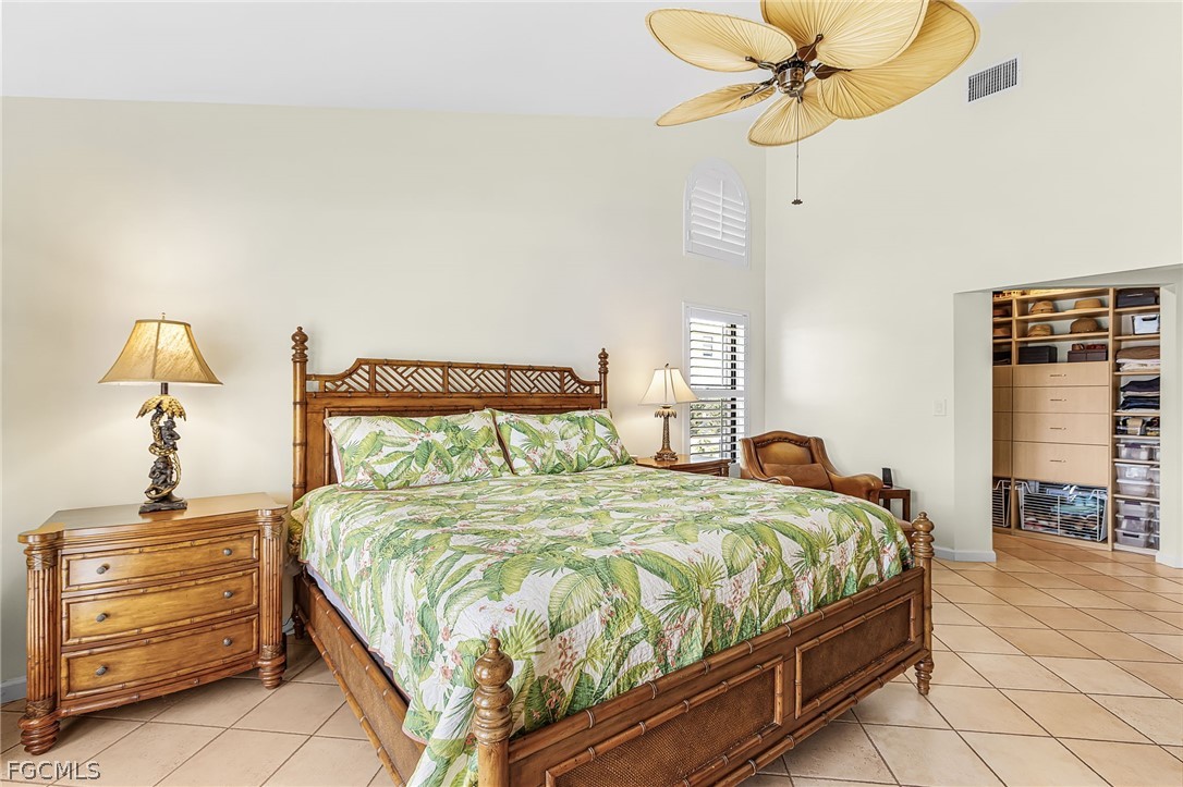 7747 Grande Pine Road Bokeelia, FL 33922 - Photo 21 of 45 a bedroom with a bed a dresser and a chandelier