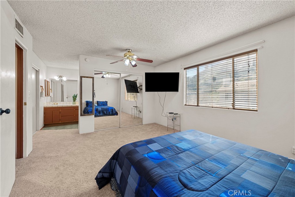 30602 San Martinez Road Val Verde, CA 91384 - Photo 22 of 47 a bedroom with a large bed and a flat screen tv