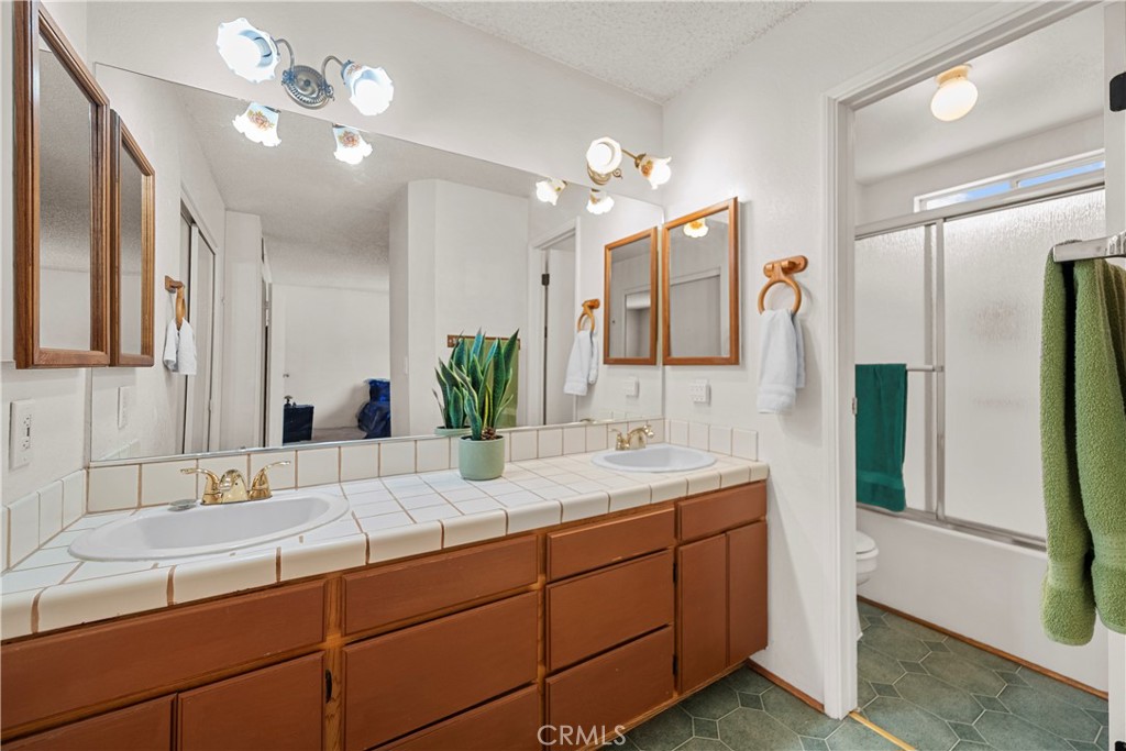 30602 San Martinez Road Val Verde, CA 91384 - Photo 23 of 47 a bathroom with a double vanity sink and a mirror