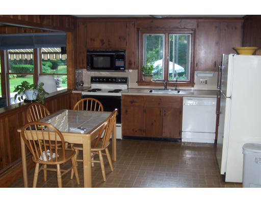 11 James Road Reading, MA 01867 - Photo 6 of 9 a kitchen with kitchen island a stove a table and a refrigerator