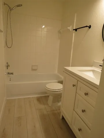 a bathroom with a granite countertop sink a toilet and shower
