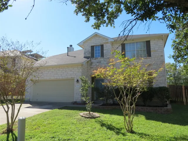 a front view of a house with a yard and potted plants