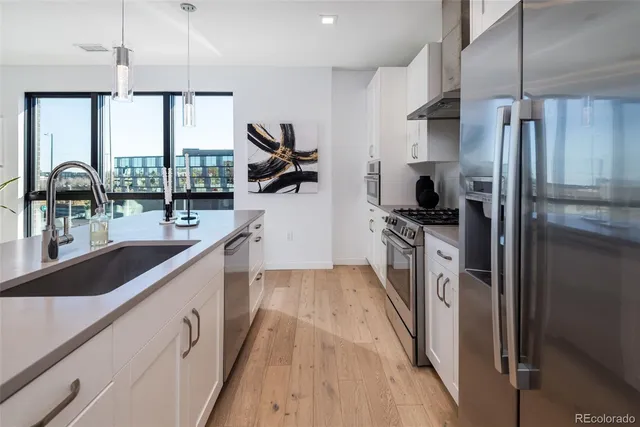 a kitchen with kitchen island granite countertop a sink appliances cabinets and a counter top space