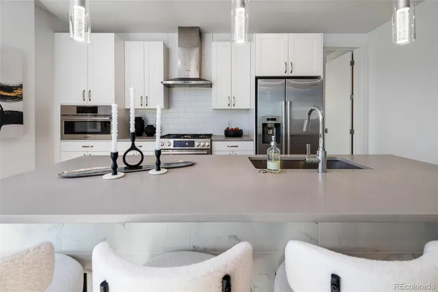 a kitchen with a sink a stove and a refrigerator with wooden floor
