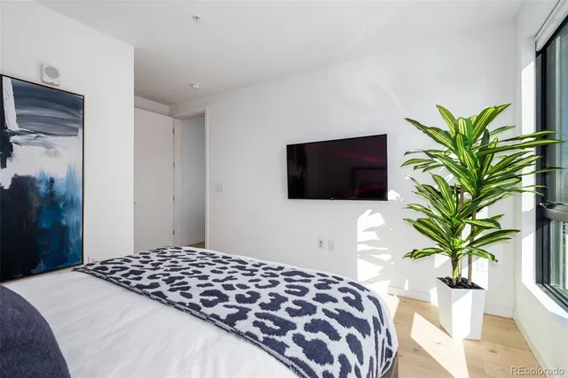a bedroom with a bed potted plants and a flat screen tv