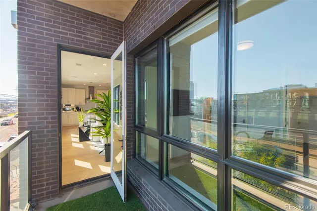 a living room with furniture potted plant and a large window